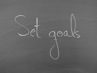 Motivational phrase 'Set goals' handwritten on a chalkboard background