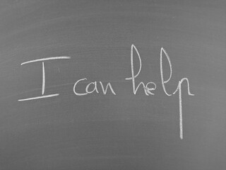 Text on a chalkboard that declares 'I can help' in handwritten chalk letters