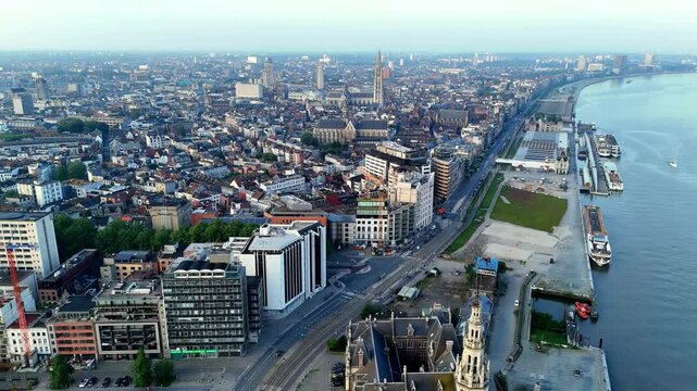high aerial perspective, captured by a drone, sprawling cityscape of Antwerp is revealed, stretching along the banks of the Scheldt River, showcasing a mix of historic architecture