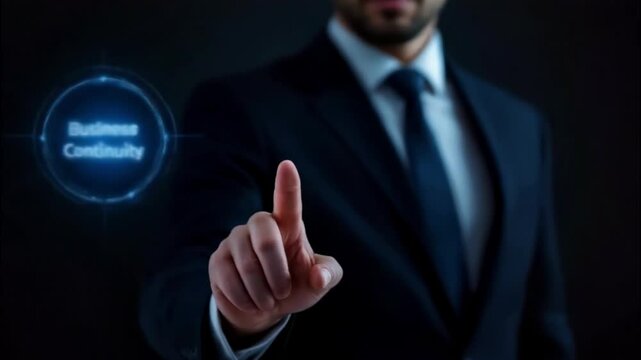A businessman pressing a button labeled 'Business Continuity'.