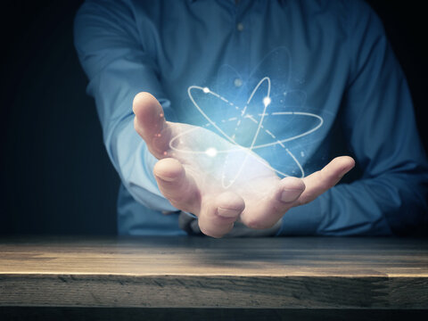 Everything is energy, businessman holding energetic ball, positive energy symbolized by atoms flying around, positive thinking, creativity, minset concept