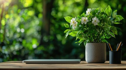 Desk with flowers, laptop, pencils; nature background; work from home