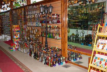 Souvenir shop on street in Egypt. Hookahs of various shapes and sizes, leather and textile products in huge variety lie on shelves of souvenir shop. Close-up. Sharm el Sheikh, Egypt - April 15, 2008