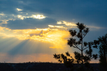 Fototapeta premium Sunset view over the hills in Ternopil oblast, Ukraine showcasing beautiful clouds and sun rays filtering through the sky