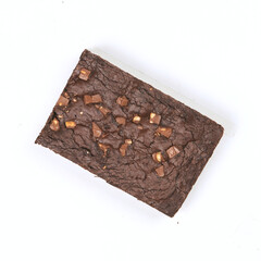 Rich chocolate brownie features a smooth texture topped with caramel pieces, showcasing a tempting dessert ready to be enjoyed