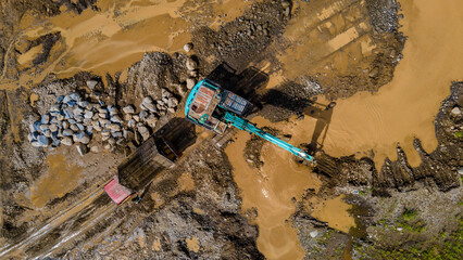 Excavator and dump truck working in rock and sand mine, Construction and mining site view from above.