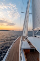 Obraz premium A sailboat is sailing on the ocean with a beautiful sunset in the background. The sail is white and the boat is large