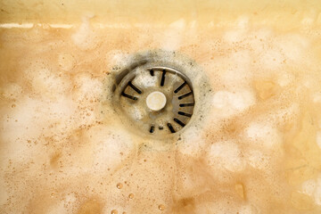 Cleaning process of a dirty kitchen sink with a metal drain using an alkaline cleaner. Foam...
