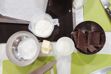 Sweet dessert ingredients like milk, chocolate, sugar and butter ready to prepare a tasty chocolate...
