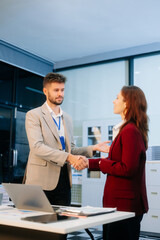 Fototapeta premium Business colleagues shaking hands in a corporate office, symbolizing partnership, teamwork