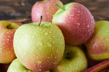 Ripe apples in a wooden box on a wooden background. Close-up.