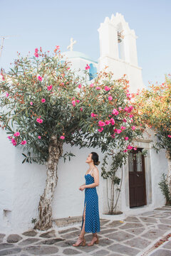 A girl is appreciating the flowers in bloom in front of a white church