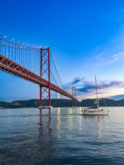 Lisbon 25 de Abril bridge with the yacht swimming by 