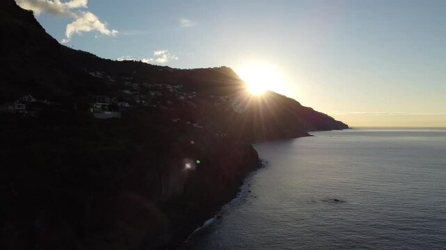 Sunrise bursts out from behind a headland in Madeira as we move across the Atlantic ocean.  