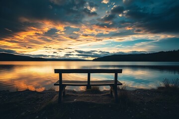 A scenic view of a tranquil lake reflecting a glowing sunset, featuring a foreground bench on the shore and vibrant skies filled with dramatic clouds