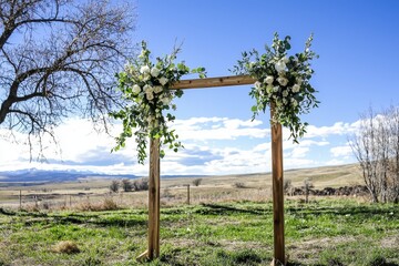 Spring Wedding Arch A wedding arch adorned with fresh flowers and greenery, set in a sunlit meadow