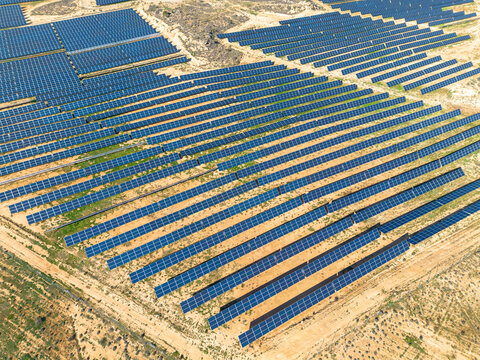 Aerial drone view of a solar farm in Teruel, Zaragoza, Spain. Rows of blue panels capture sunlight, blending technology and nature to produce clean energy