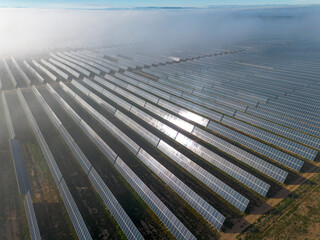 Aerial drone view of a solar farm in Teruel, Zaragoza, Spain. Rows of blue panels capture sunlight, blending technology and nature to produce clean energy
