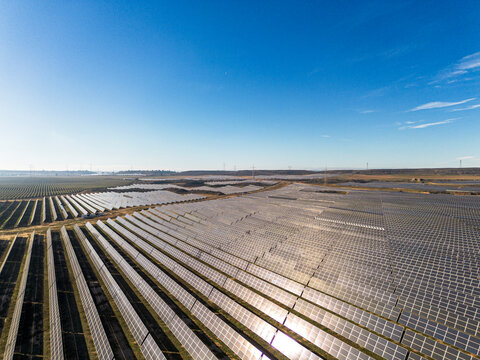 Aerial drone view of a solar farm in Teruel, Zaragoza, Spain. Rows of blue panels capture sunlight, blending technology and nature to produce clean energy