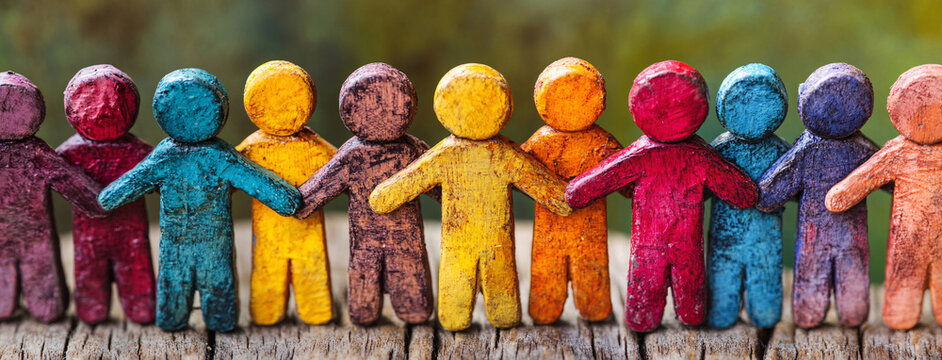 Handcrafted wooden figures in vibrant colors standing together in unity