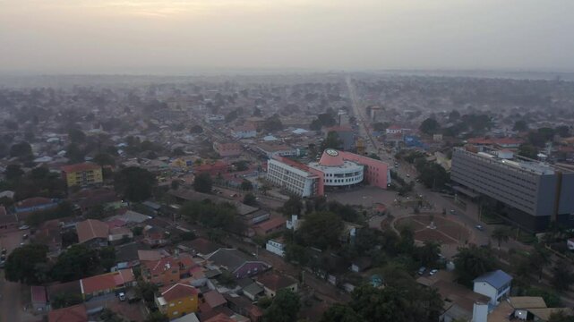 A Bustling Cityscape With Vibrant Buildings and Roads Weaving Through the Community in Guinea-Bissau, West Africa - Aerial Drone Shot