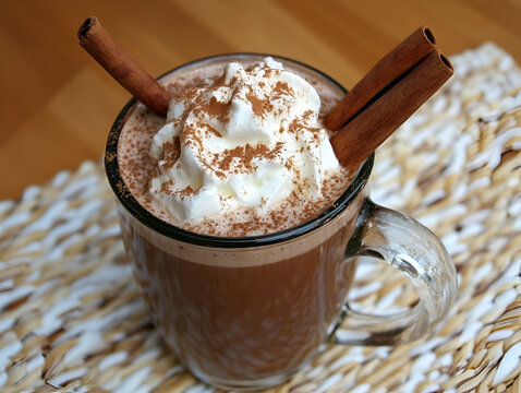 Spiced Hot Chocolate Indulgence: A steaming mug of rich hot chocolate topped with a dollop of whipped cream and garnished with cinnamon sticks, promising warmth and comfort. 