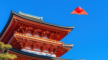 Obraz premium Red Kite Soaring Above Japanese Temple Architecture in Vivid Blue Sky