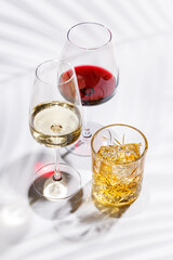 A refined composition of wine glasses filled with red and white wine, paired with a whiskey glass