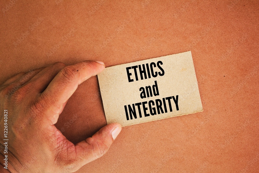 Poster hand and paper with the words ethics and integrity. integrity is understood as a consistent applicat