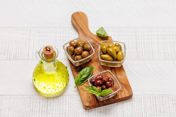 An assortment of various olives presented in a bowl, showcasing different colors, textures, and...