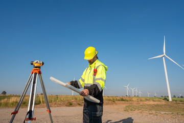 Engineer wearing uniform inspection and survey work in wind turbine farms rotation to generate...