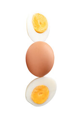 Top view of raw chicken egg and peeled cooked or boiled egg with egg yolk in two halves in stack isolated with clipping path in png file format