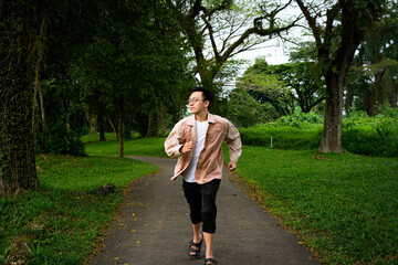 Fototapeta premium Man Jogging Along a Curved Path in a Peaceful Green Park