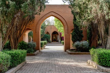 Fototapeta premium Stunning view of the red brick arches and lush greenery in a serene garden courtyard during daylight hours in a peaceful retreat location