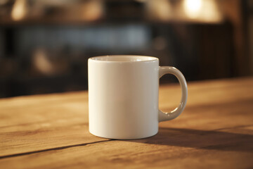Obraz premium White company branded coffee mug standing on a wooden table in a cafe, representing brand identity and coffee culture