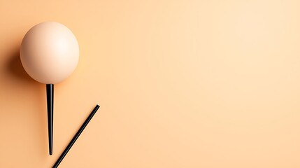 Beige Sphere and Black Sticks on Pale Peach Background