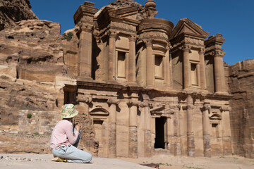 Girl is watching on Al Dayr, the ancient rock-cut monument in Petra. A UNESCO World Heritage site, perfect for travel guides, historical documentaries, and cultural tourism promotions.