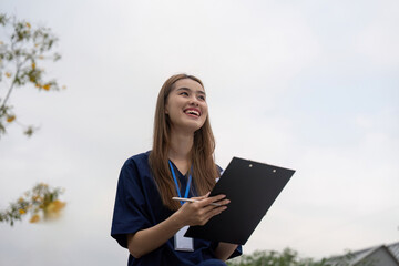 Fototapeta premium Nurse smiling while reviewing patient notes on a clipboard during a break