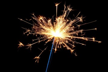 Sparkler brightens night sky during celebration for festivities with vibrant sparks and joyful atmosphere