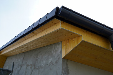 Detail of the edge of the roof with the batten. It is wooden in the color of pine.