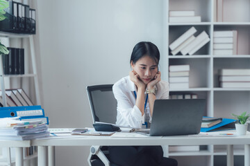 Concentrated Focus: A businesswoman in a white shirt, her hands resting on her chin, intensely...