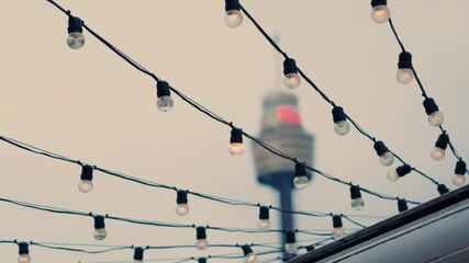 Light Bulbs Hanging At A Restaurant Venue With Centre Point In Background In Sydney, Australia - Low Angle