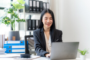 Focused on the Task: A young, professional woman with a bright smile and determined look works...