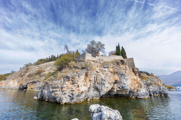 Picturesque scene featuring Ohrid Lake with the historic Church of St. John at Kaneo perched on a...