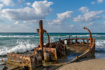 Abandoned rusty shipwreck at HaBonim Beach Nature Reserve on the Mediterranean Sea in Israel.
