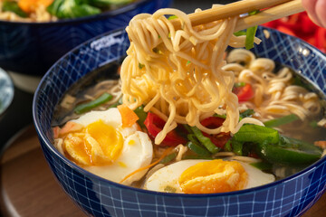Japanese noodle soup ramen with egg and vegetables in blue ramen bowl	