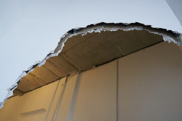Broken drywall, a background crack with a white wall texture. With space to copy. High quality photo