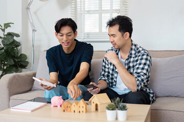 Fototapeta premium Couple discussing finances with models and a piggy bank in a cozy setting