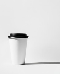 White disposable coffee cup with black lid on white background. (2)
