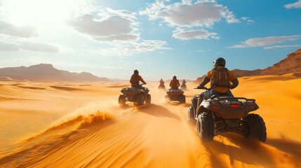Four wheeled vehicle riders on sand dunes, mountains in background, outdoor recreation